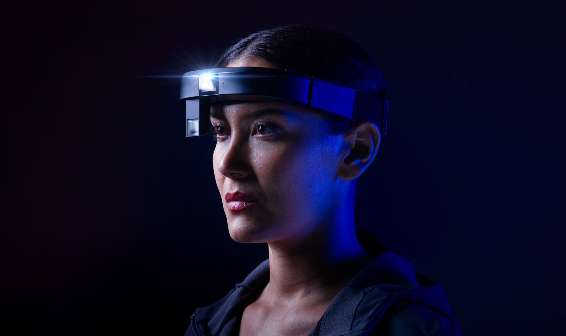 Woman wearing the RealWear Arc 3 against a dark background