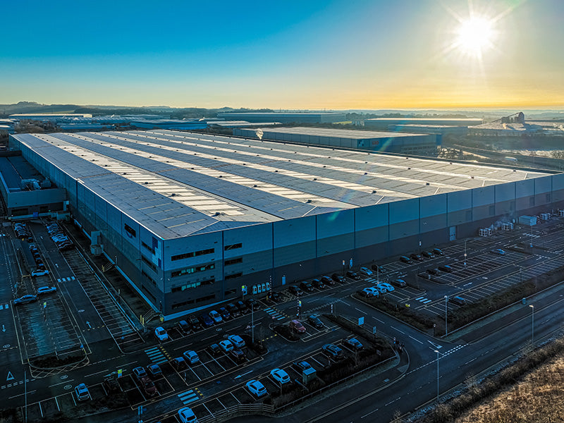 Large industrial building with solar panels at sunset